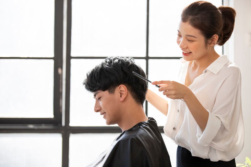 美容院でカットしている美容師と男性