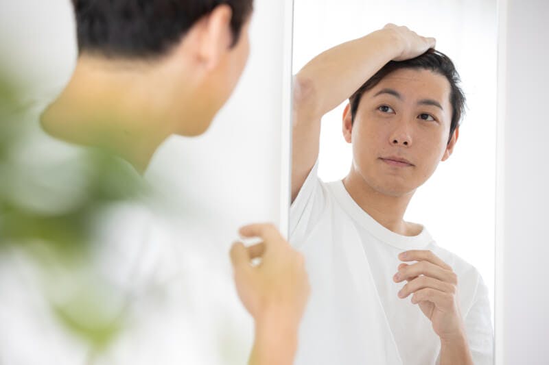 髪の毛を確認する男性