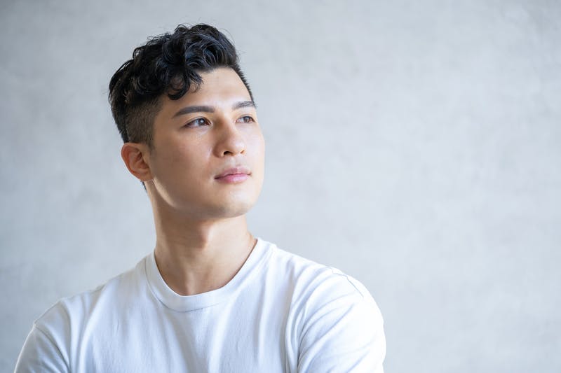 ツーブロックでトップにボリュームを出した髪型の男性