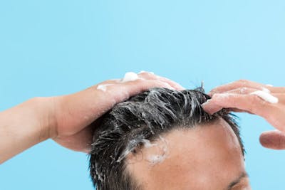 シャンプーしている男性の手元と髪