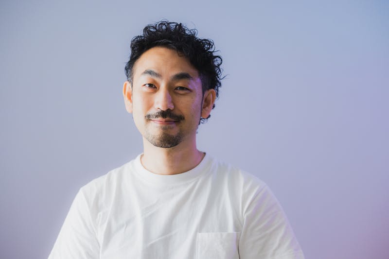 サイドを刈り上げスパイラルパーマを当てたひげ面の男性