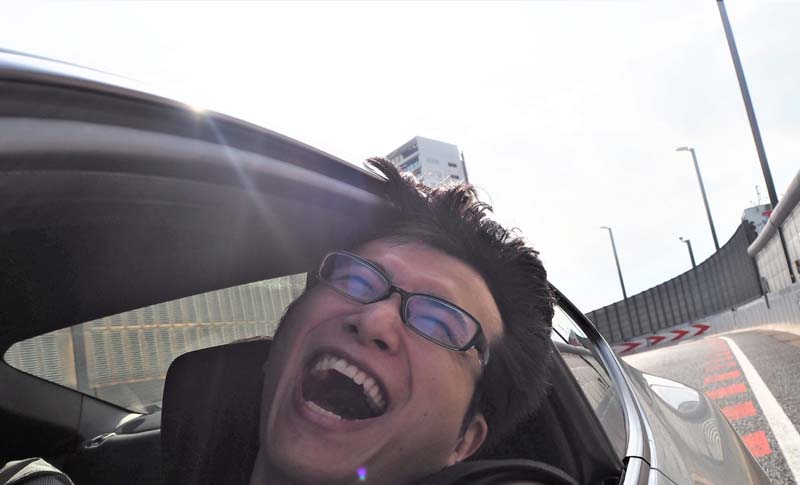 首都高のトンネルを抜け、大爆笑のコクブさん（強風で前髪が持ち上がっている様子1）