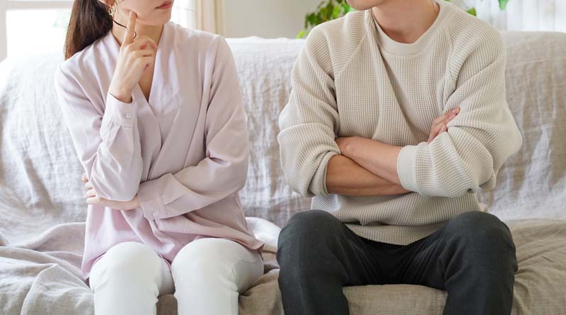 男性と女性が腕を組みながら、疑問を話し合っているイメージの画像