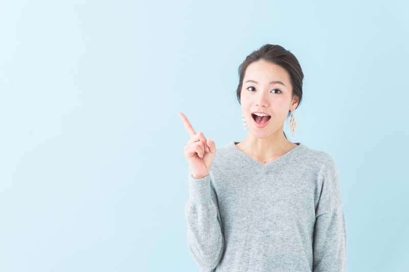 笑顔の女性が人差し指を立てている写真