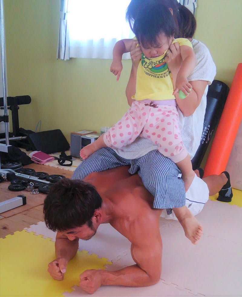 ご自宅で筋トレ中の諸橋晴也さん。奥様と愛娘を乗せての体幹トレーニング
