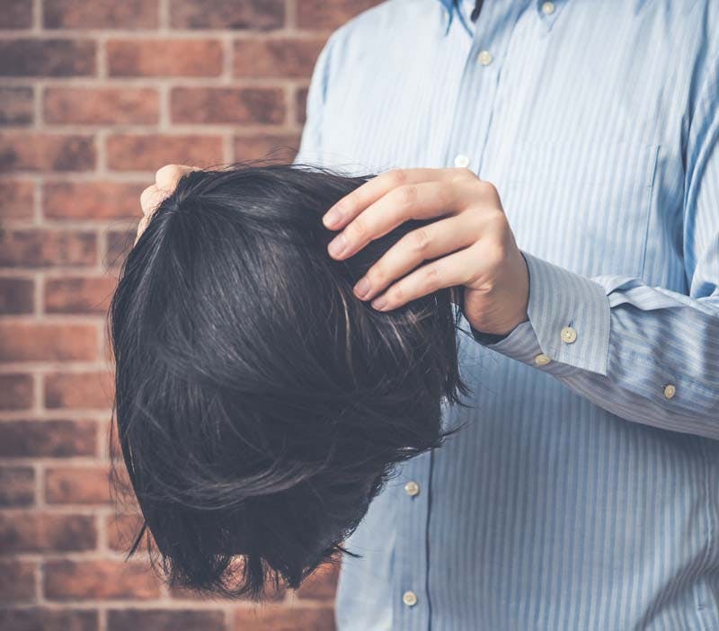 男性がウィッグを装着するイメージ画像