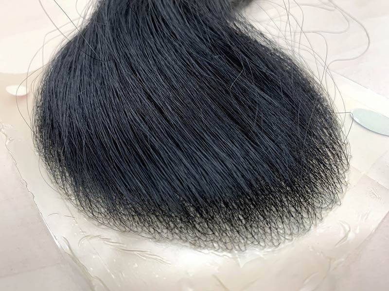 貼るカツラ（ウィッグ）の毛髪をひっぱった様子のイメージ画像