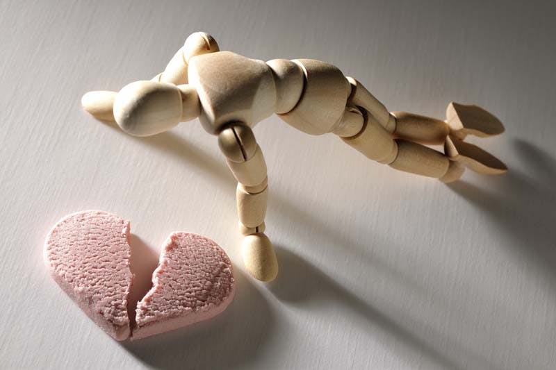 ハートが割れて落ち込む男性のイメージ画像