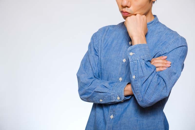 顎に手を当てて考える男性の画像