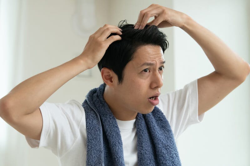 髪の毛を気にする男性
