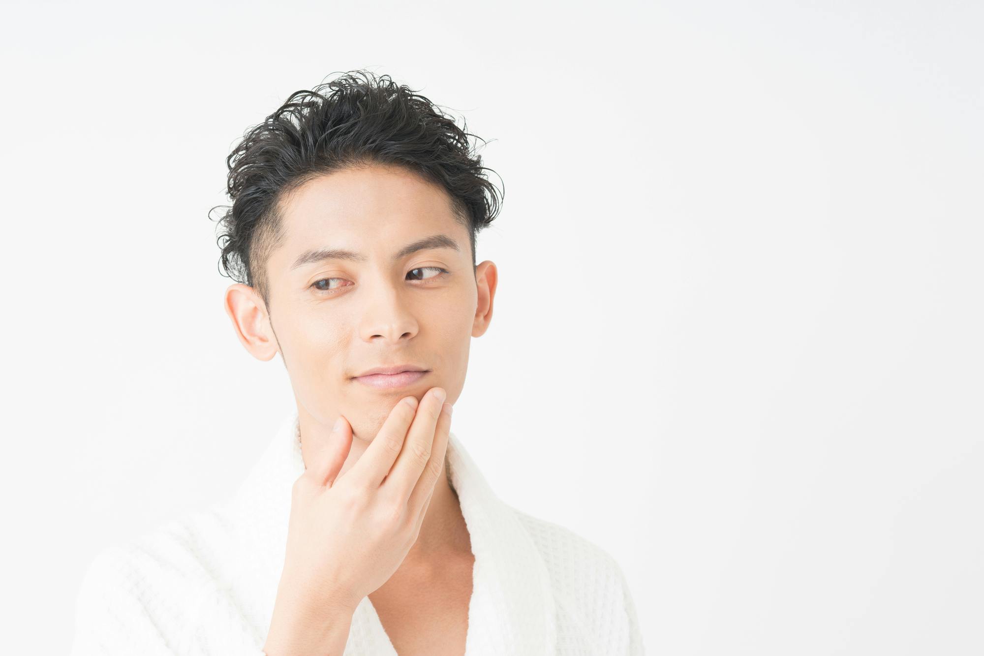 ワイルドなパーマをかけた髪を立ち上げ、側頭部をツーブロックにした男性のアップ