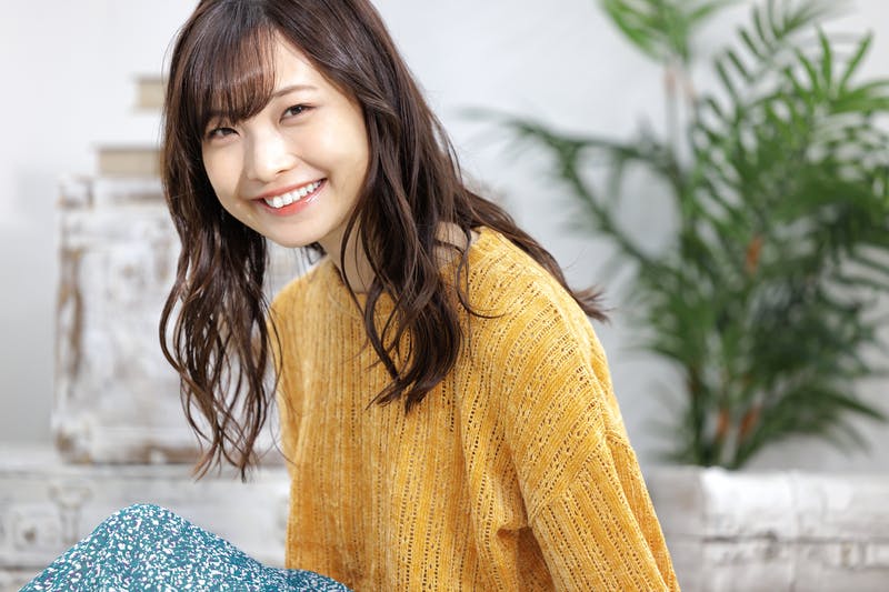 カメラ目線で微笑むロングヘアの女性