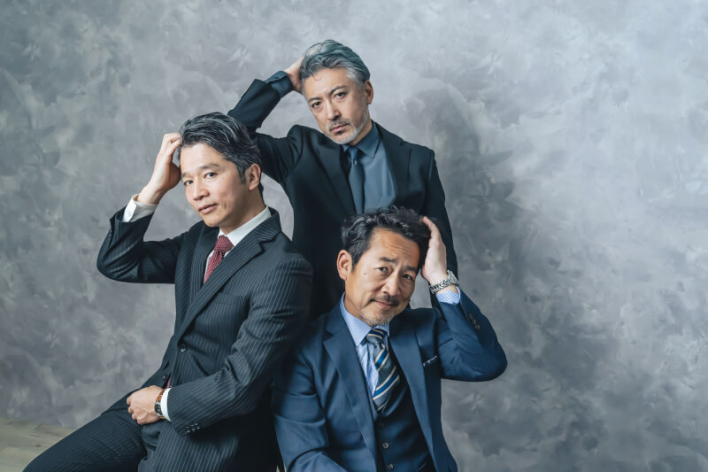 スーツ姿の中高年男性3人が頭に手を当てているポートレート