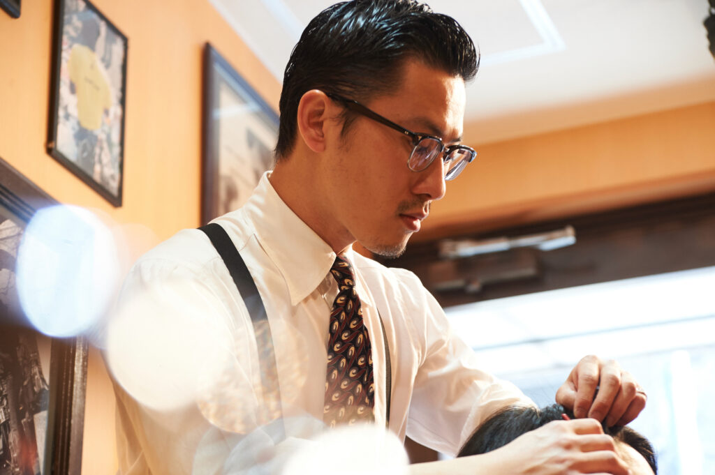 男性客の髪を整える理容師
