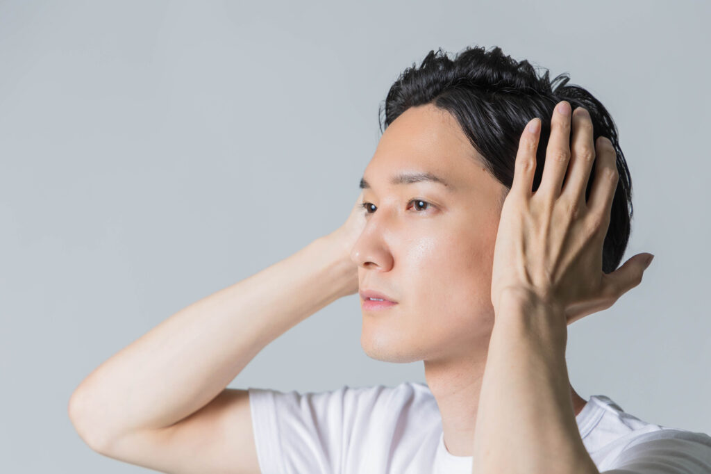 頭髪をチェックしている男性