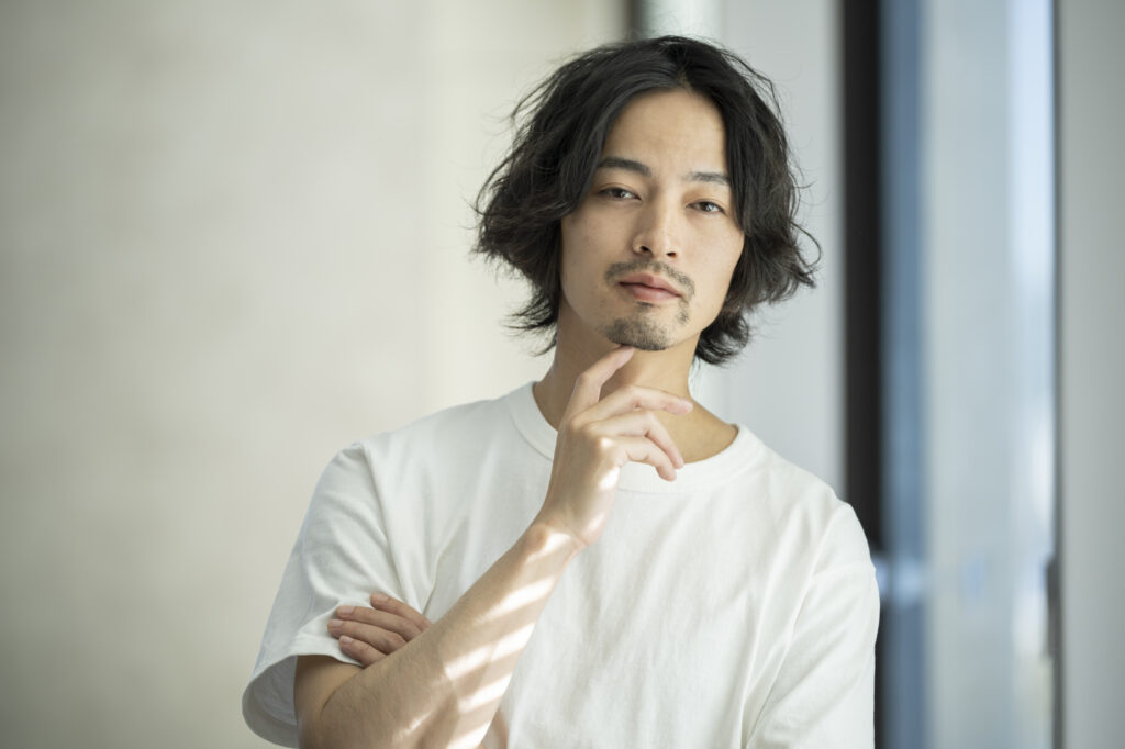 顎に手を当てている男性
