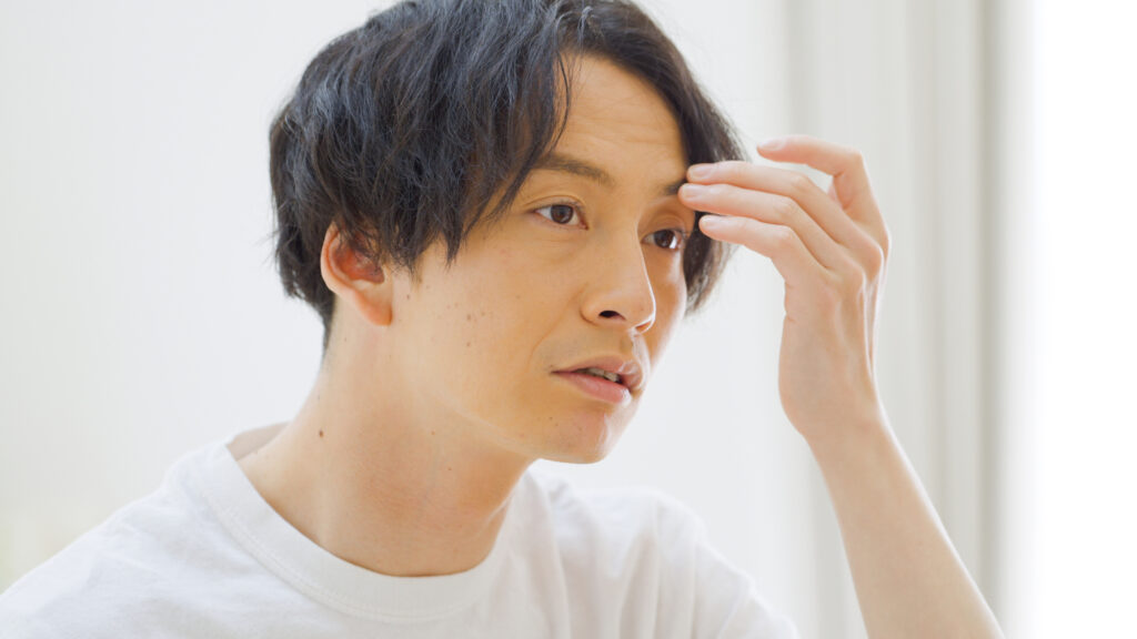 前髪を触る男性